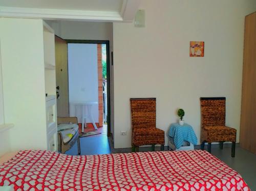 MongioveにあるAgriturismo Aiolia - Panorama Eolieのベッドルーム1室(赤いベッド1台、椅子2脚付)