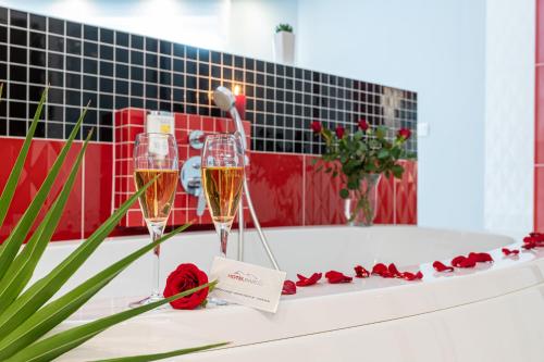 two champagne glasses and roses on a bath tub at Hotel Bardo in Bardo