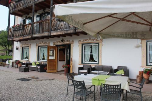 a patio with a table and chairs and a balcony at Rifugio Caltena in Fiera di Primiero