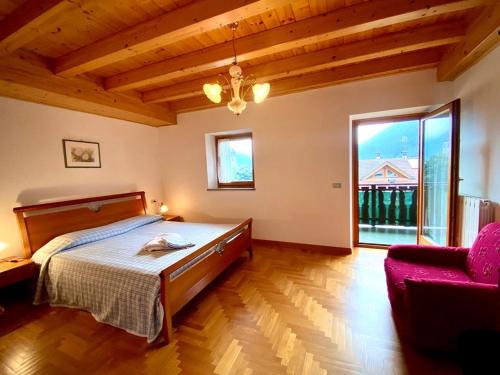 1 dormitorio con cama y ventana grande en Casa Ortensia, en Pellizzano