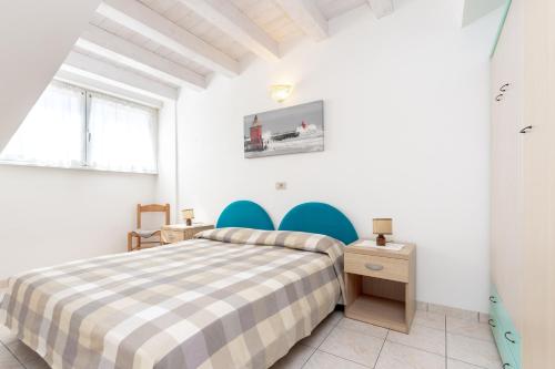 Ένα ή περισσότερα κρεβάτια σε δωμάτιο στο Appartamenti Lignano Sabbiadoro - Villa Ammiraglia