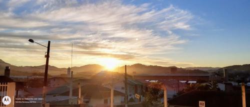 a view of a city with the sun setting at Hotel Norte Blu in Blumenau