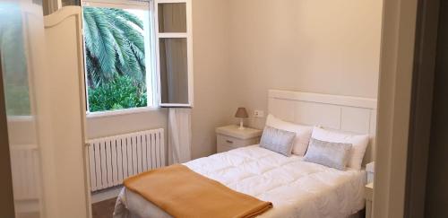 - une chambre avec un lit blanc et une fenêtre dans l'établissement Casa Do Maruxo, à Pontevedra