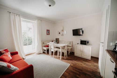 a living room with a red couch and a table at EnjoyTheAlps - Appartements BARBARA in Flachau