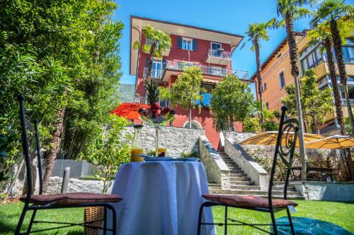 a table with two chairs and a building in the background at VILLA MURALTO Boutique Hotel Rooms and Garden in Locarno
