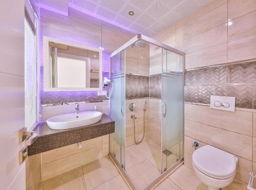 a bathroom with a toilet and a sink and a shower at Hamarat Otel in Kaş