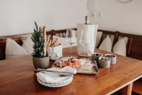 a table with a plate of food and a glass of wine at EnjoyTheAlps - Appartements BARBARA in Flachau