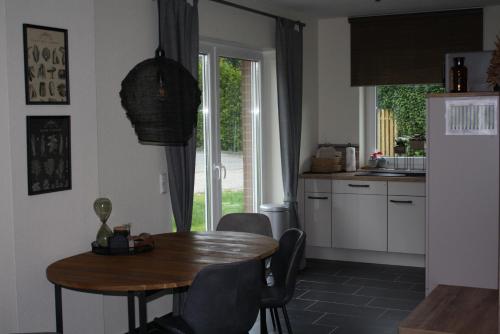 uma cozinha com uma mesa de madeira, uma mesa e cadeiras em Haus Bootsmann em Krummhörn