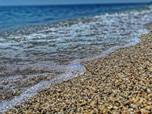 a close up of the sand and water on a beach at Ivonnis Garden in Mesimvría