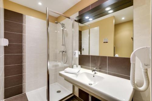 La salle de bains est pourvue d'un lavabo et d'une douche. dans l'établissement Résidence Les Alizés, à La Brède