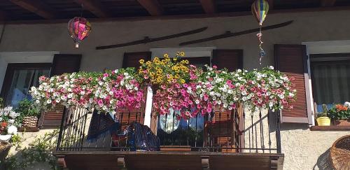 a balcony filled with flowers on a house at Bed & Breakfast Barba Bertu in Frassino
