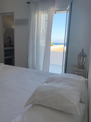 a white bed with a view of the ocean at Astrofegia guest house in Donoussa