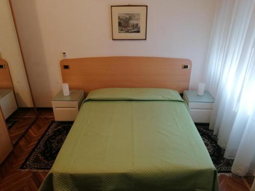 1 dormitorio con 1 cama verde y 2 mesitas de noche en Sacco Bed&Breakfast, en Rovigo