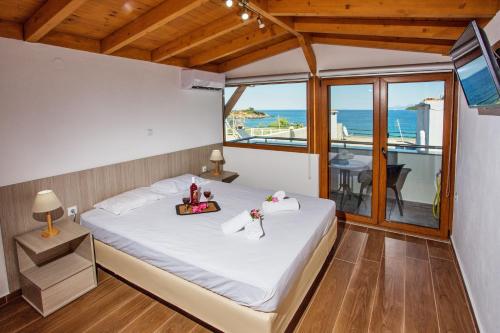 a bedroom with a bed with a view of the ocean at The Blue Beach Apartments in Nea Peramos