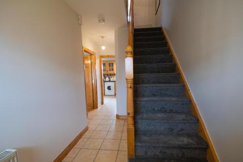 a staircase in a home with a blue carpet at Beautiful Three Bedroom home in Bundoran in Bundoran