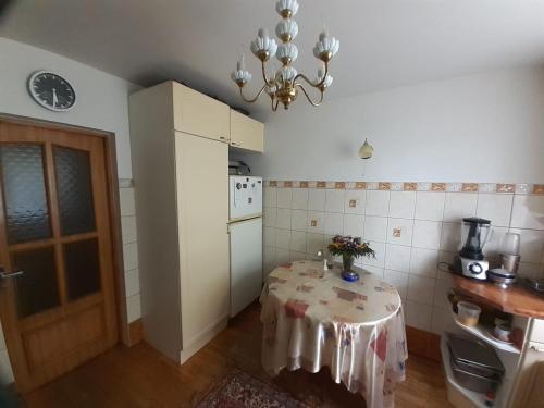 a small kitchen with a table and a chandelier at IOMAN HAUS in Ikšķile