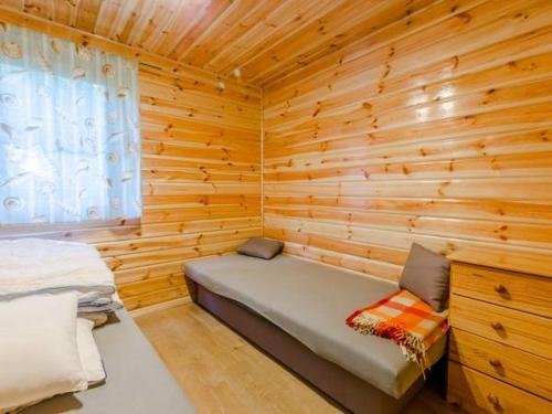 Zielona Dolina Rusinowo في ريوزينو: كابينة خشب مع سرير في غرفة