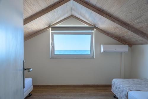 a bedroom with a window in a roof at Despina Apartments in Plataniás