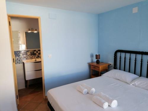 a bedroom with a bed with two rolled towels on it at Casa Cabo de Gata in Retamar