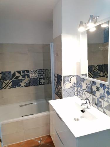a bathroom with a sink and a tub and a mirror at Casa Cabo de Gata in Retamar