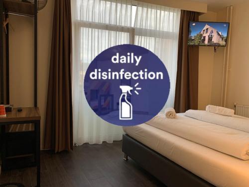 a blue sign that says daily disinfection in a bedroom at Orange Tulip Hotel in Amsterdam