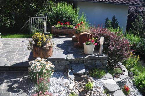 a garden with two potted plants and flowers at Ferienwohnung Haus König in Türnitz