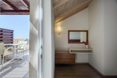 a bathroom with a sink and a mirror on a balcony at Despina Apartments in Plataniás