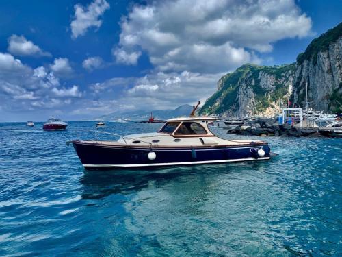 a boat floating in the water near a beach at Gresy Appartamento Suite in Positano