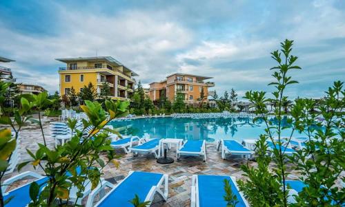 a pool at a resort with blue chairs and condos at Dreamland Oasis of happiness in Chakvi