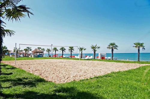 a sandy beach with palm trees and the ocean at Dreamland Oasis of happiness in Chakvi