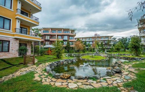 a garden with a pond in front of a building at Dreamland Oasis of happiness in Chakvi