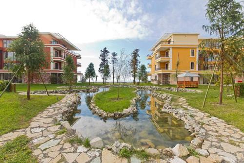 a pond in the middle of a park with buildings at Dreamland Oasis of happiness in Chakvi