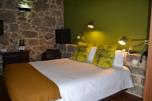 a bedroom with a white bed with yellow pillows at Quinta do Medronheiro Hotel Rural in Viseu