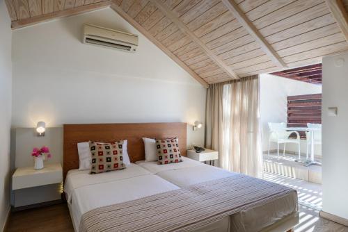 a bedroom with a large bed and a balcony at Despina Apartments in Plataniás