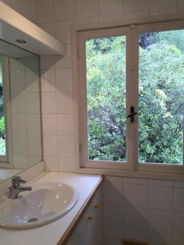 une salle de bain avec un lavabo et une fenêtre dans l'établissement Villa Bellochio, à Menton