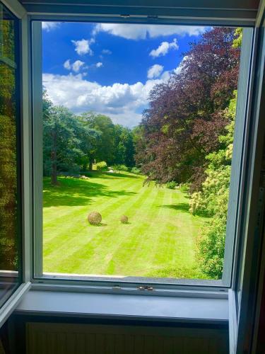 a window with a view of a field of grass at la Tour d'Héloïse - 10' de Bruxelles in La Hulpe