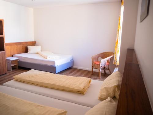 um quarto com duas camas e uma cadeira em Gasthof Meindl em Lustenau