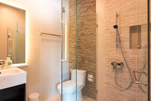 a bathroom with a shower with a toilet and a sink at Ravin Home ราวินโฮม in Nakhon Nayok