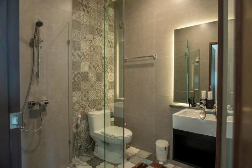 a bathroom with a toilet and a glass shower at Ravin Home ราวินโฮม in Nakhon Nayok