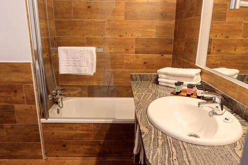 a bathroom with a sink and a bath tub at Hostal La Guineu in Viladrau