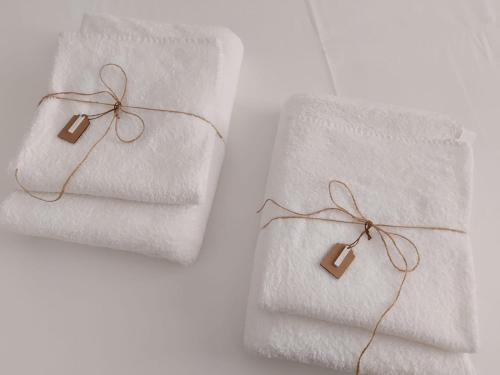 two white towels with brown tags on them at Isabella d'Aragona Guest House in Barletta