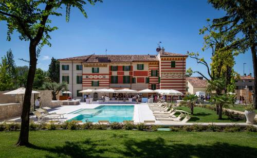 a large building with a swimming pool in front of it at Boutique Hotel Villa Zoppi - Adults only in Colognola ai Colli