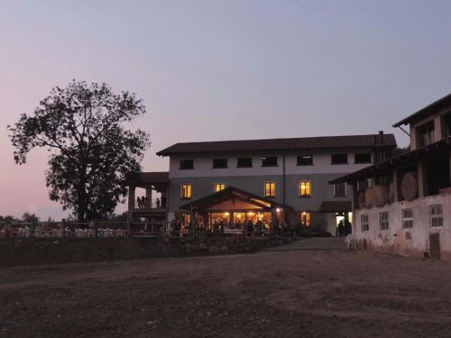 a large building with tables and chairs in front of it at Agriturismo Il Balcone sulla Valle in Bedero Valcuvia