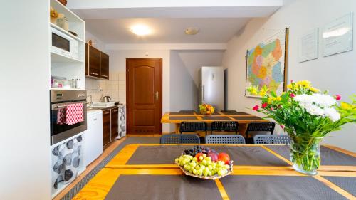 a kitchen with a table with a bowl of fruit at Leśniczówka pod Śnieżką in Bukowiec