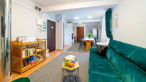 a living room with a green couch and a table at Leśniczówka pod Śnieżką in Bukowiec