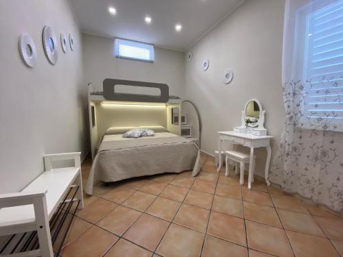 a bedroom with a bed and a table and a mirror at La casa di Vesta in Pompei