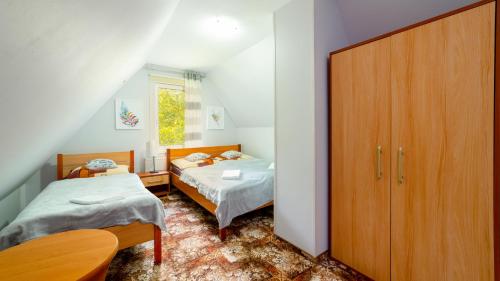 a small bedroom with two beds and a closet at Leśniczówka pod Śnieżką in Bukowiec