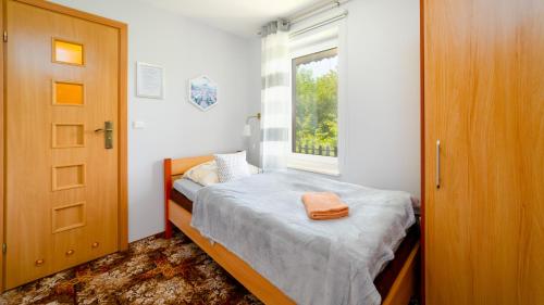 a small bedroom with a bed and a window at Leśniczówka pod Śnieżką in Bukowiec