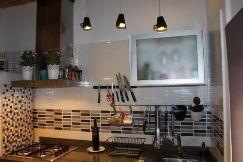 a kitchen with a sink and a tv on the wall at Casa Rural Ventanas a la Sierra in Higuera de la Sierra