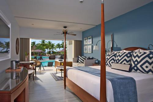 a bedroom with a bed and a living room at Secrets St. James in Montego Bay